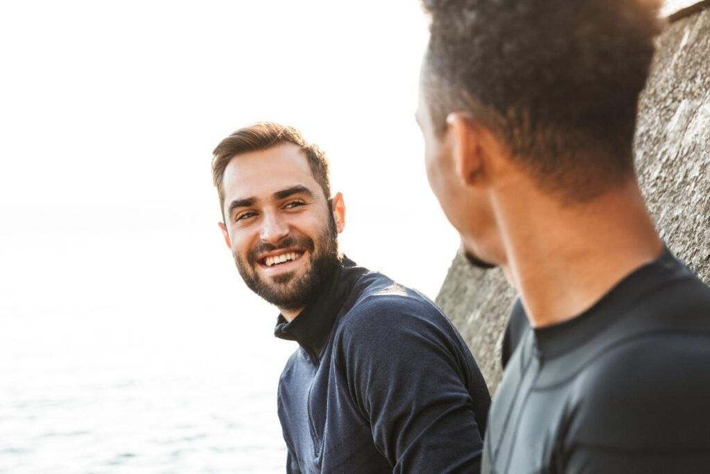 a man smiles at another man who is in his opioid rehab